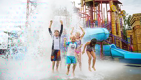 Des enfants sautent sous l'eau au Parc attraction glissades d'eau Complexe Atlantide